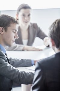 Three business people sitting at a table and having a business meeting